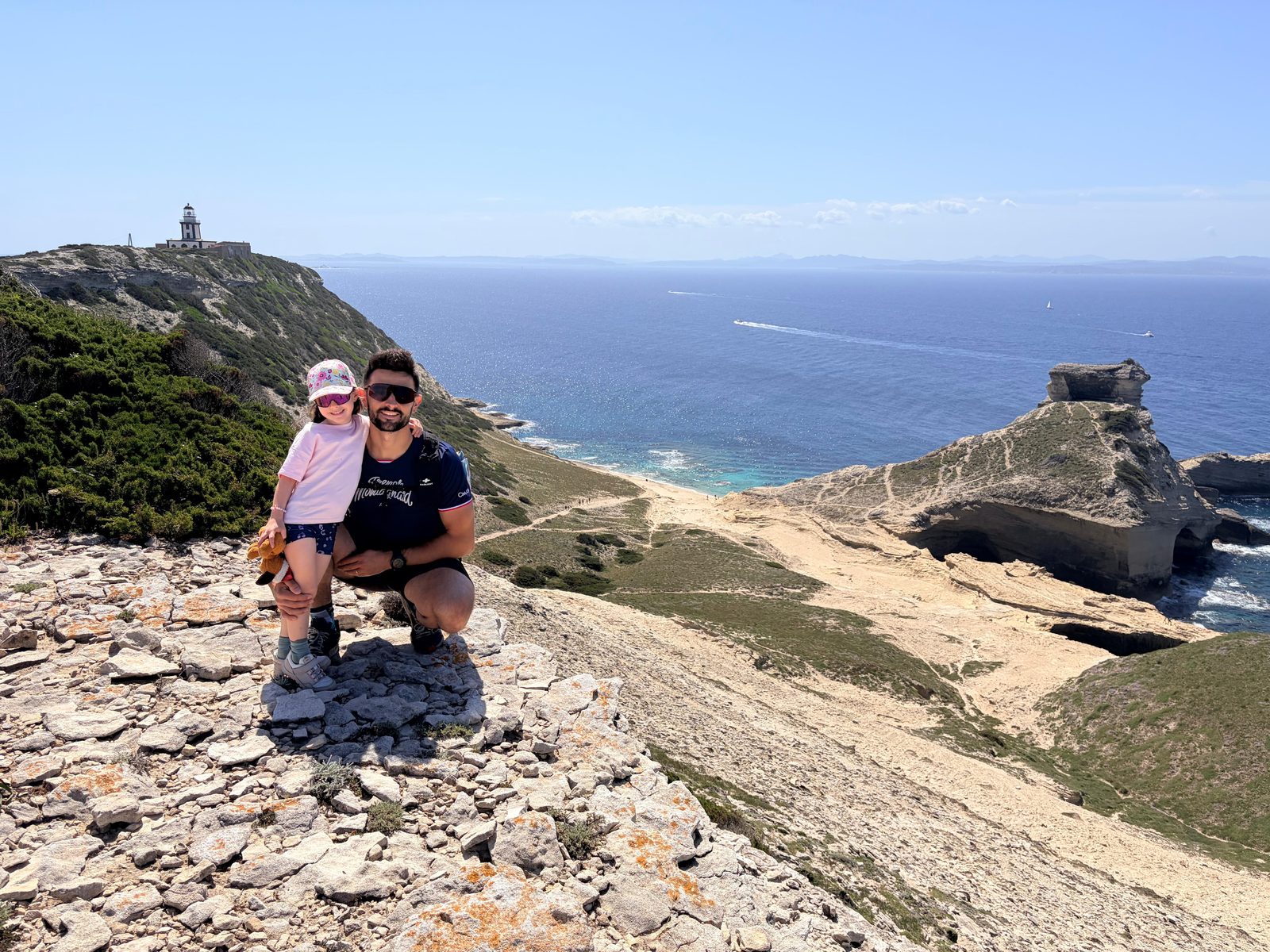 Antoine et sa fille sur une falaise face à la mer, souriants